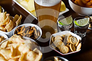 Set of various snacks, pint of lager beer in a glass, a standard set of drinking and eating in a pub