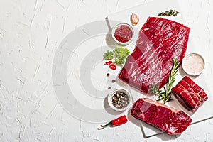 Set of various steaks with spices and herbs. Eye round, flank and striploin steaks