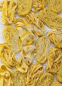 Set of various uncooked pasta on white wooden surface, top view. From above, overhead. Close-up