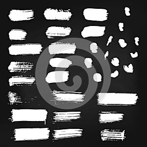 Set of vector white paint brush spots on chalkboard background. Big set of watercolor strokes isolated on black. Grunge
