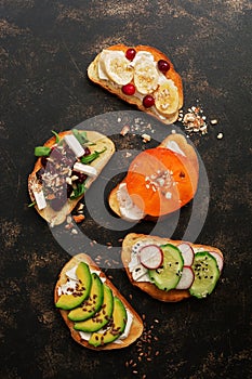 Set of vegan sandwiches with vegetables and fruits on a dark rustic background. Top view, flat lay. Vegetarian snack