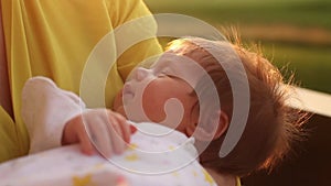 Set of videos of woman in yellow blouse dandling her little baby in pink blanket