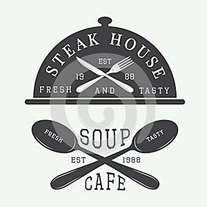 Set of vintage cafe and steak house logo, badge and emblem with spoons, forks and knifes