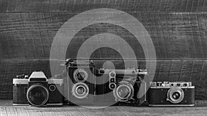Set of vintage film camera from the times of the USSR on a wooden background, closeup, copy space. Line of old retro cameras.