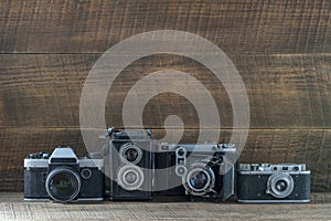 Set of vintage film camera from the times of the USSR on a wooden background, closeup, copy space. Line of old retro cameras