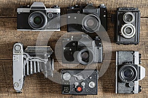 Set of vintage film camera from the times of the USSR on a wooden background, closeup, top view. Line of old retro cameras