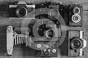 Set of vintage film camera from the times of the USSR on a wooden background, closeup, top view. Line of old retro cameras. Black