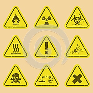 Set of warning signs on vector grunge background. Nine Symbols of hazard warning on cardboard background