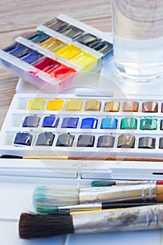 Set of watercolor paints with brushes