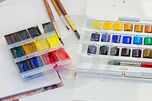 Set of watercolor paints with brushes