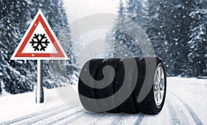 Set of wheels with winter tires and road sign outdoors