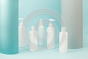 Set of white cosmetic bottles with soft shadows on light blue background. Home and beauty salon care concept, mock up, copy space