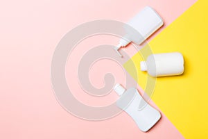 Set of White Cosmetic containers  on yellow background, top view with copy space. Group of plastic bodycare bottle