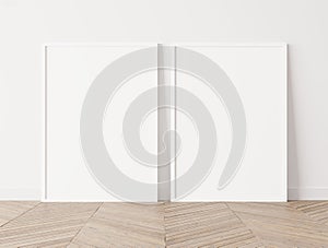 Set of 2 white frames a3, a4, frame mock up on white wall standing on wooden floor.