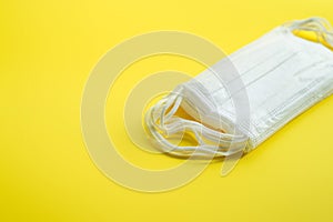 Set of white medical masks isolated on yellow background.