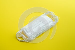 Set of white medical masks isolated on yellow background.