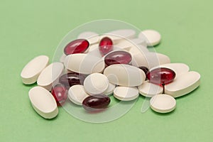 A set of white pills and red gelatinous capsules.