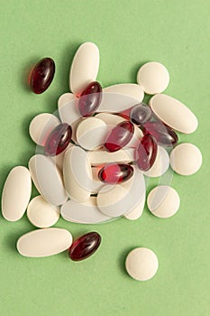 A set of white pills and red gelatinous capsules.