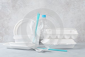 Set of white plastic disposable tableware and packaging photo