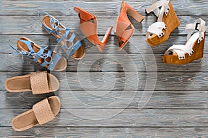 Set of womens shoes wedges, heels and flat sandals on grey woo