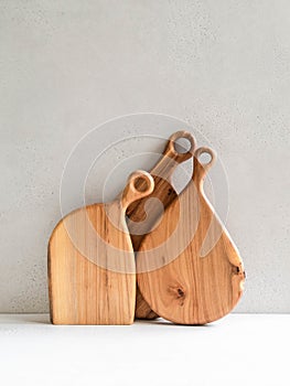 Set of wooden cutting boards layout against the gray wall. Minimal kitchen concept. copy space