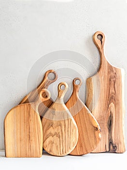 Set of wooden cutting boards layout against the gray wall. Minimal kitchen concept. copy space