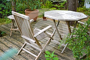 A set of wooden and lightly weathered patio furniture on a terrace