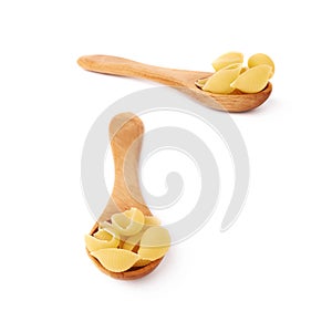 Set of wooden spoon filled with dry conchiglie pasta over isolated white background