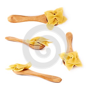 Set of wooden spoon filled with dry farfalle pasta over isolated white background