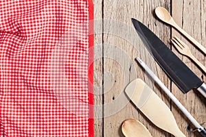 Set of wooden spoon,fork,knife,and red napkin on old wooden table background,top view copy space for your product and cooking