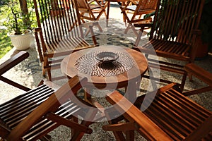 Set of wooden table and chairs in the garden. Teak wood furniture stand on the terrace
