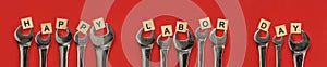 Set of worn and used wrenches holding wooden blocks with Happy Labor Day text, celebrating American workers