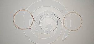 Set of wound steel and bronze acoustic electric guitar strings rolled up and formed on isolated and white background