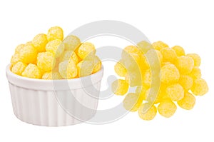 Set of yellow corn sticks balls as heap and in ceramics bowl isolated on white background.