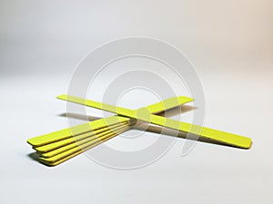 Set of yellow disposable nail files on a gray gradient background photo