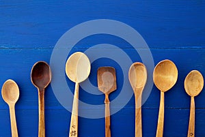 Set of yellow wooden vintage spoons on a blue wooden background