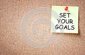 Set your goals concept. sticky pinned to corkboard with room for text.