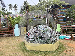 A large pile of glass bottles stacked in a yard.