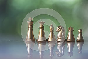 Sets of golden chess pieces on nature background, king, rook, bishop, queen, knight, and pawn