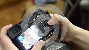 She sets up the camera before shooting. Man turns the wheels of the camera's settings and presses the button on the rear