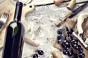 Setting with bottle of red wine, grape and corks