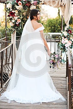 Setting off on a beautiful new journey. Rearview shot a beautiful young bride standing outdoors on her wedding day.