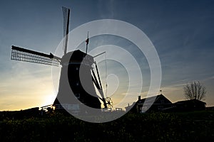 The setting sun behind the windmill Tweemanspolder Nr. 4 near the Rottemeren, Zevenhuizen, The Netherlands