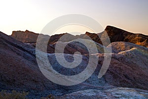 Setting Sun on the colourful eroded mountains ridges, ancient rock formations of the hottest place on earth, Death Valley