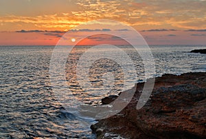 Setting sun over the sea and rocks