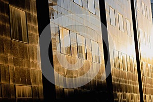 Setting sun is reflected in the windows of a tall glass office building in the old center of Bucharest