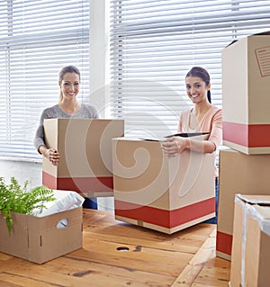 Settling into their new office space. two casual businesswomen moving into a new office.