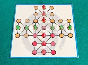 Setup of cross solitaire board game on green table