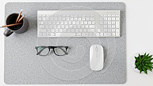 Setup featuring a white keyboard and a wireless mouse on a light gray