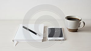 Setup featuring a white notebook with a black pen a smartphone